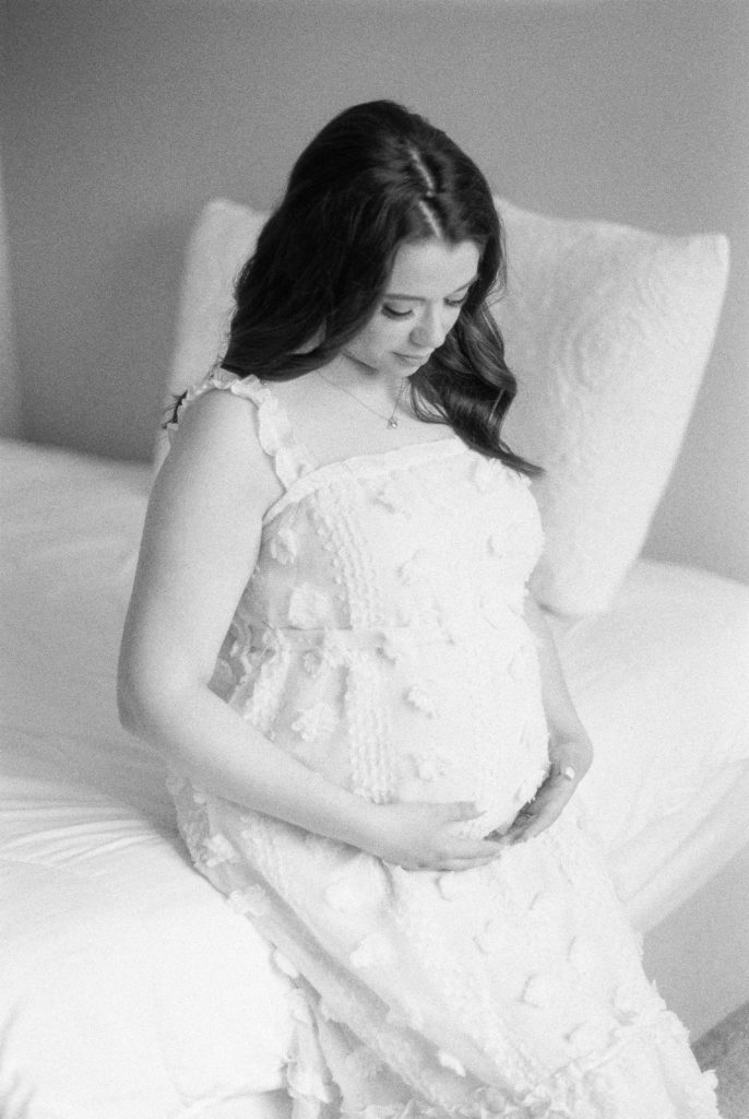 Glowing mother holding her growing bump, shot on black and white film captured by Edmonton maternity photographer, Kahla Kristen Photography