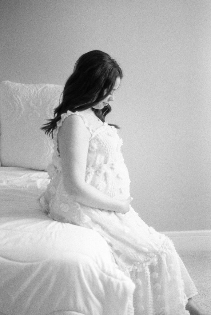 expectant mom holding her bump on black and white film captured by Edmonton maternity photographer, Kahla Kristen Photography