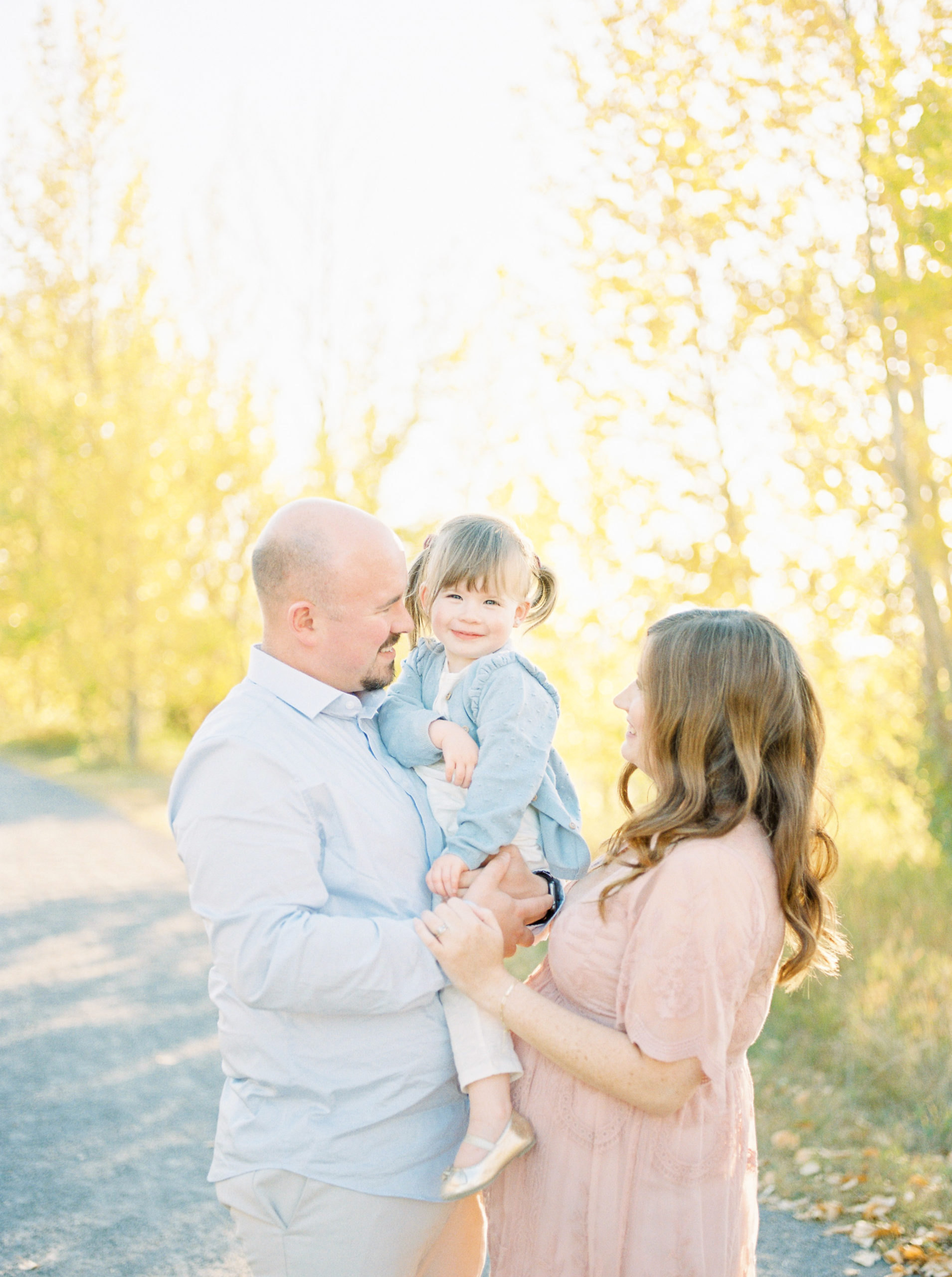 Expectant mom and dad with smiling toddler in fall photography edmonton session