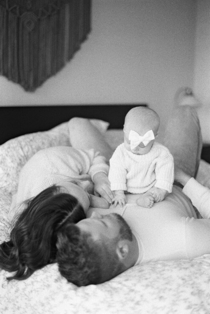 black and white image of six month old baby with mom and dad, newborn photography in Edmonton by Kahla Kristen Photography