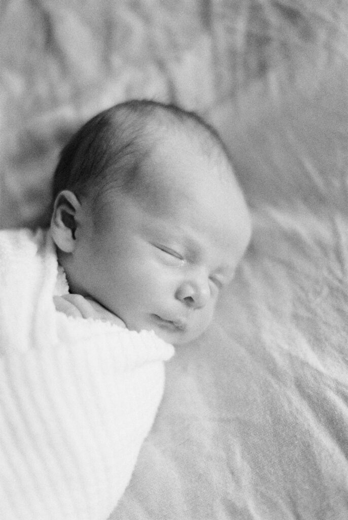 Edmonton newborn photography black and white image of baby boy, laying on bed
