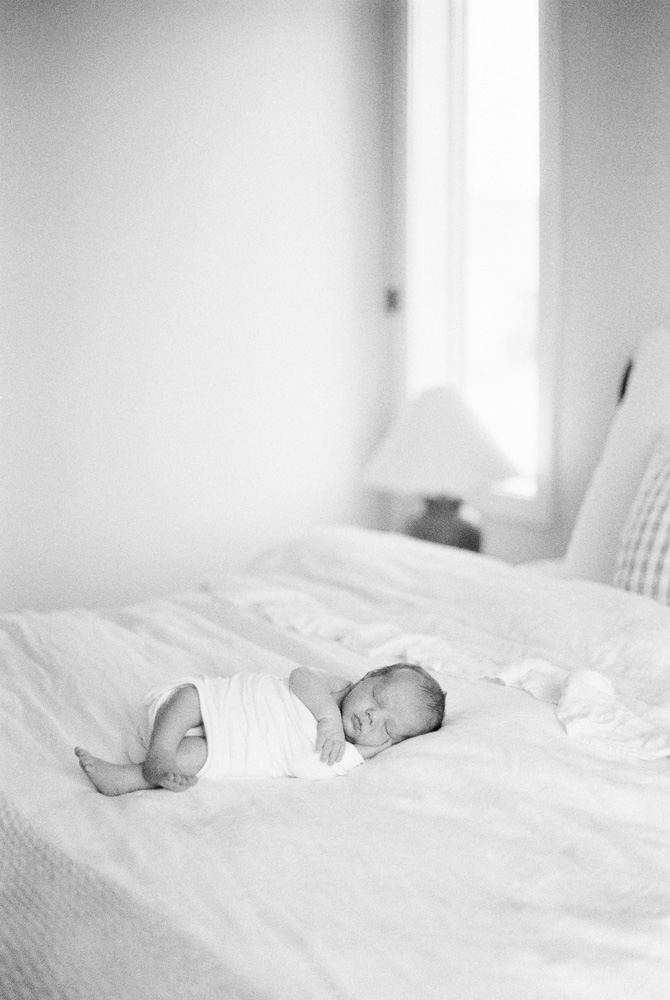 at home baby photography with baby snuggling on bed