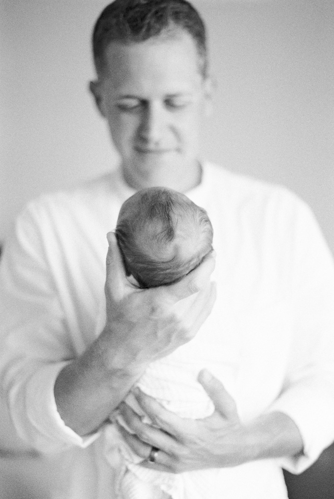 at home baby photography with dad and baby snuggling in dads arms