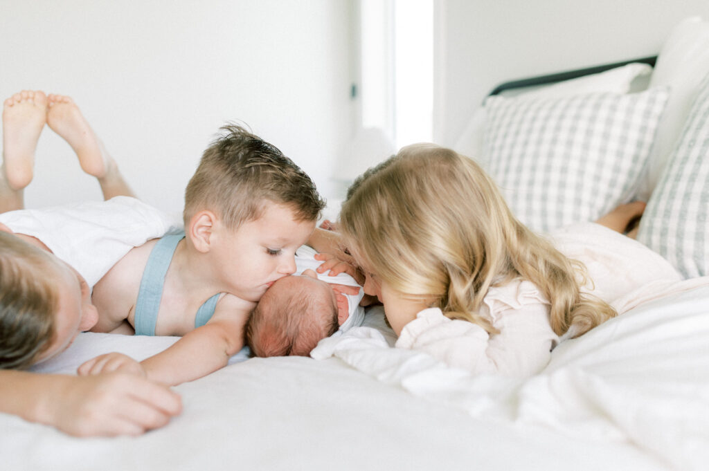 at home newborn image of four siblings, snuggling new baby boy