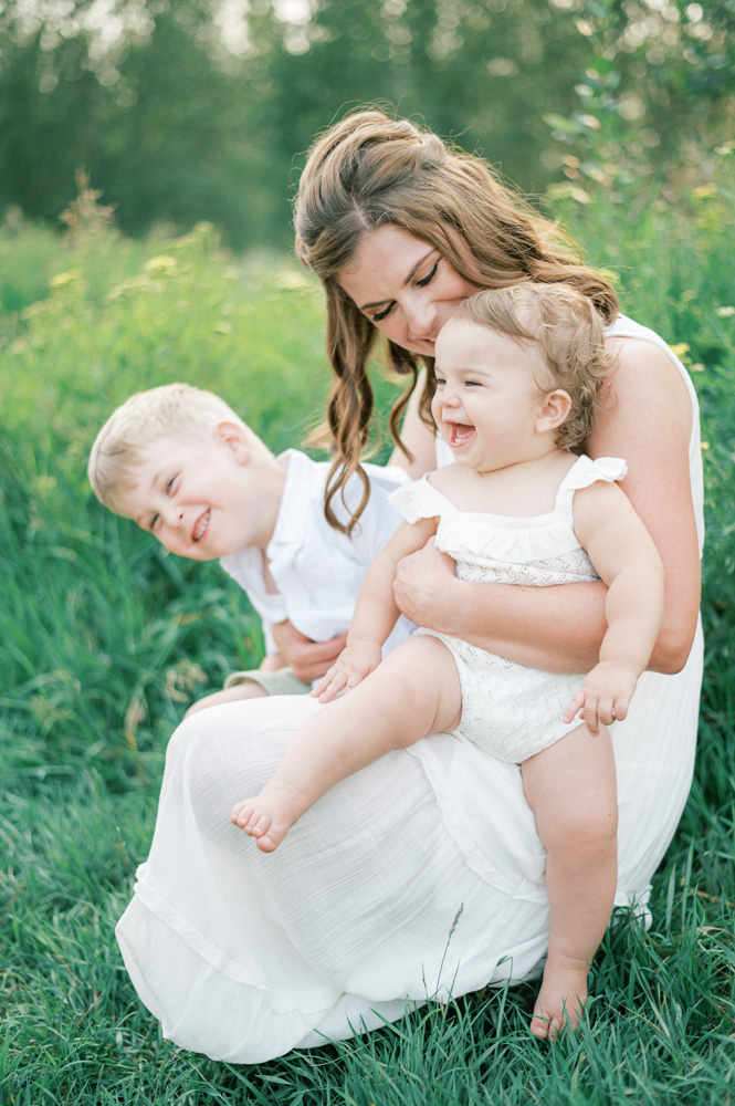 what to wear to summer family photos, mom and kids in soft neutrals cuddling on beautiful summer evening