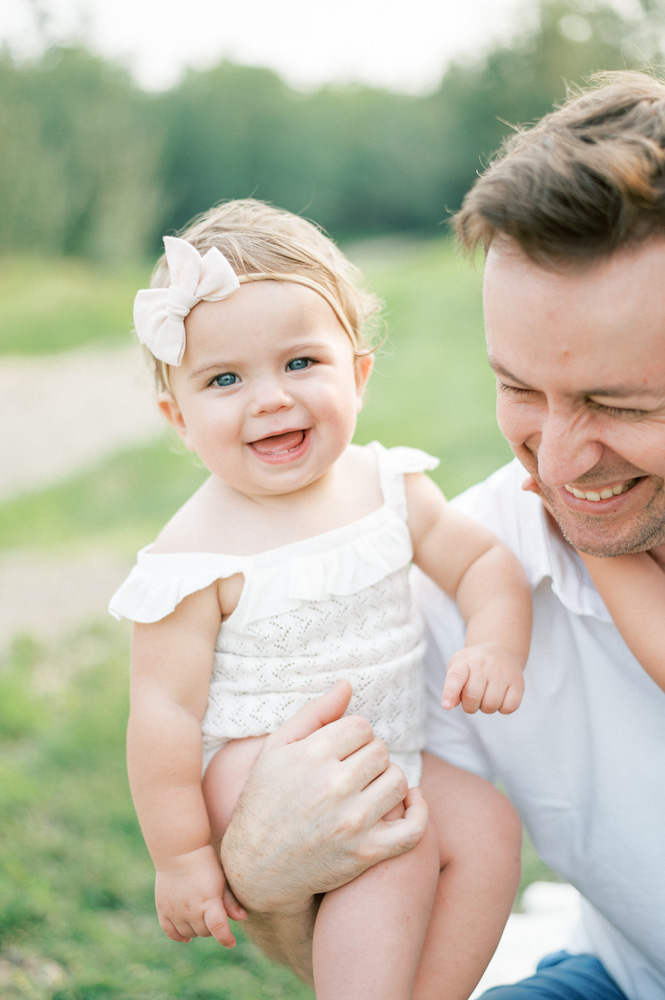 What to wear for summer family photos, baby girl smiling in dad's arms in beautiful summer session