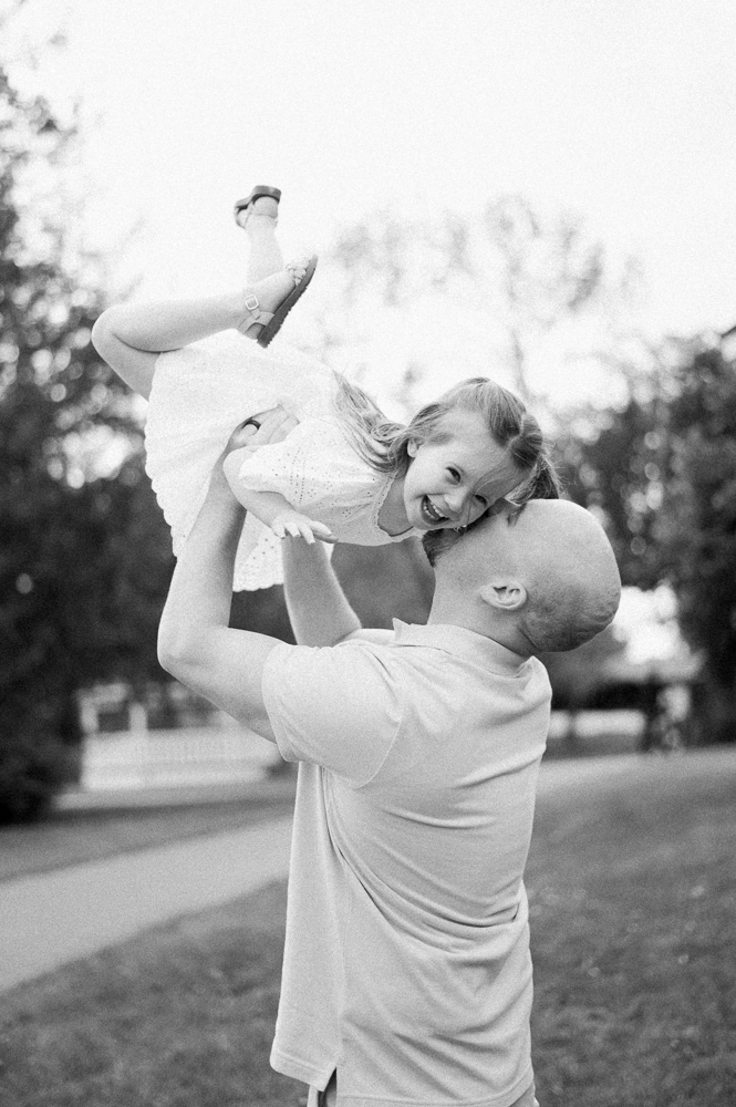 Dad holding daughter in the air and daughter is laughing