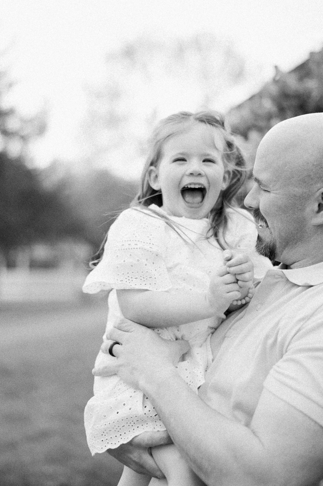 Dad holding daughter on beautiful summer evening at ice cream shop in Edmonton