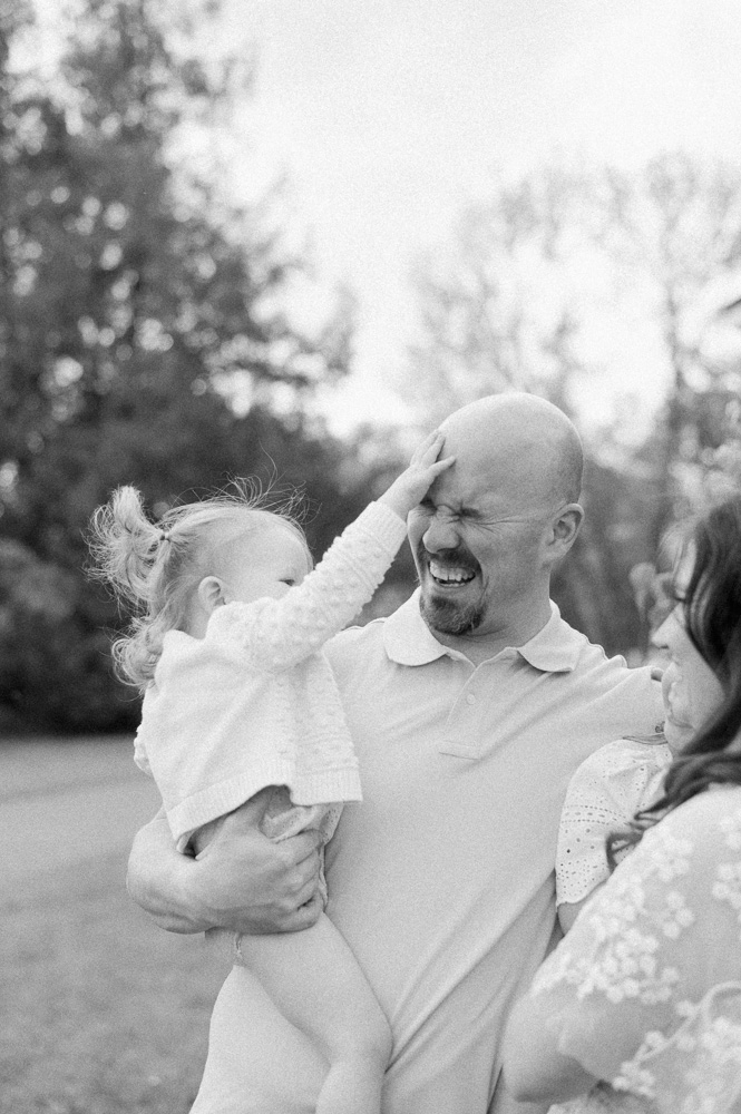 Dad and daughter laughing together on a beautiful summer evening at the best ice cream shops in Edmonton, Millers