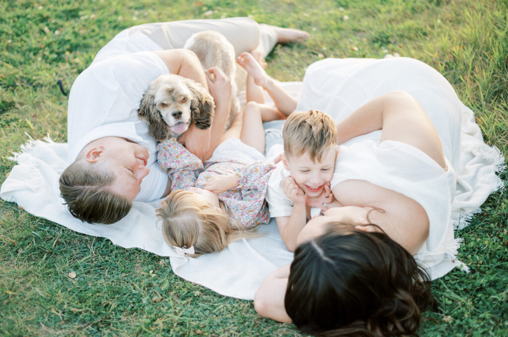 Whole family snuggling on a blanket outdoors