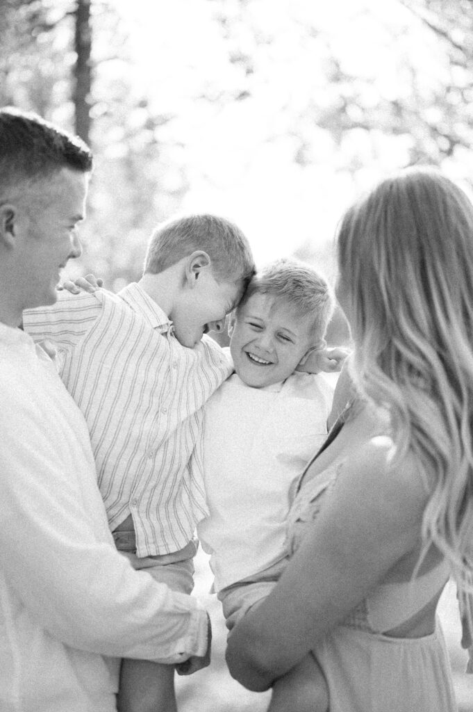 The Importance of Family Pictures - two boys in mom and dad's arms captured in black and white, by Kahla Kristen Photography