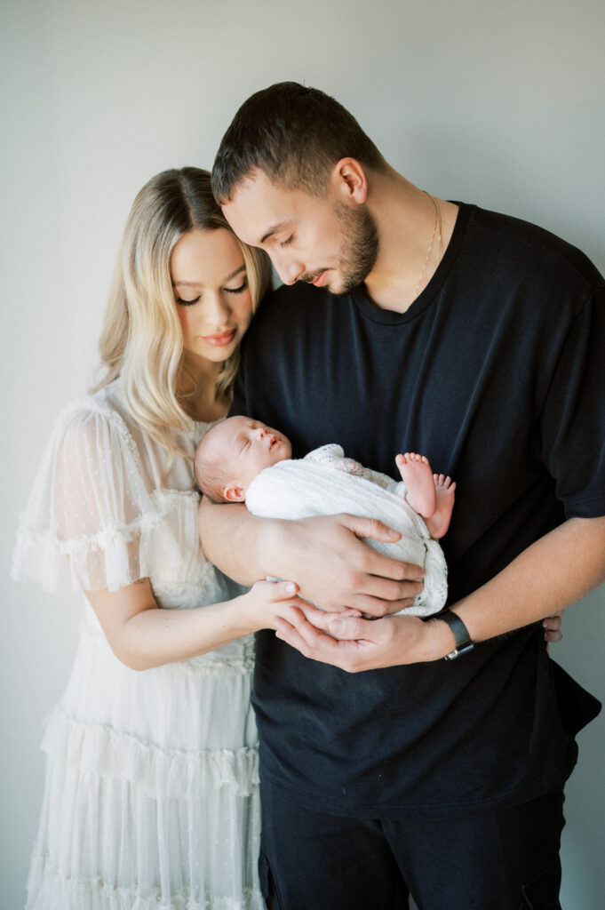 Couple holding a newborn baby.